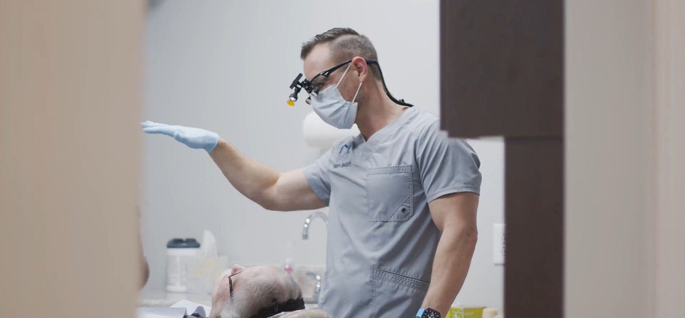 Altavista dentist wearing a face mask and dental binoculars while talking to a patient