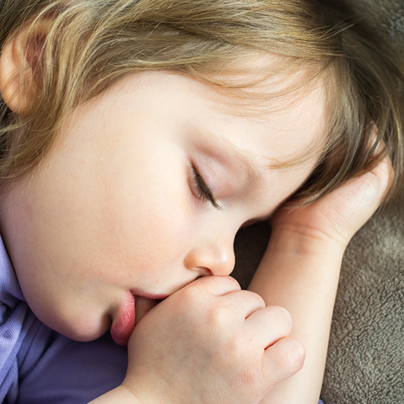 Child sleeping while sucking their thumb