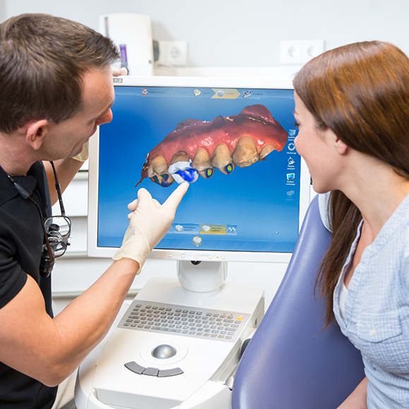 Dentist showing a patient a digital impression of their teeth on a screen