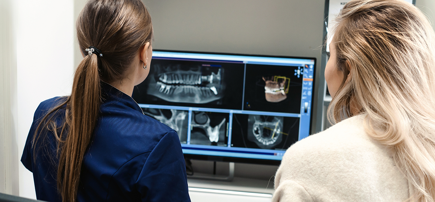 Dentist showing a patient digital x rays of their teeth and jaw