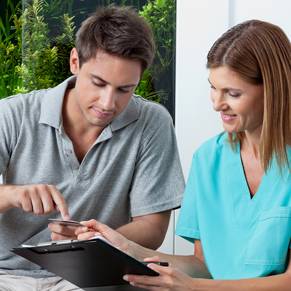 Dental team member showing a clipboard to a patient