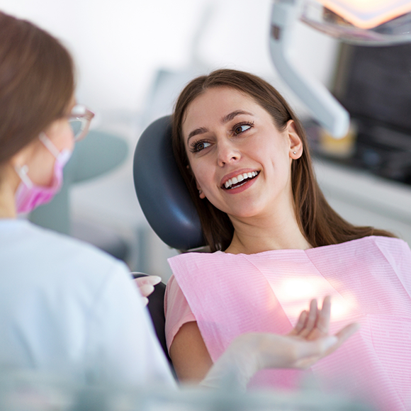 Woman in dental chair listening to her dentist