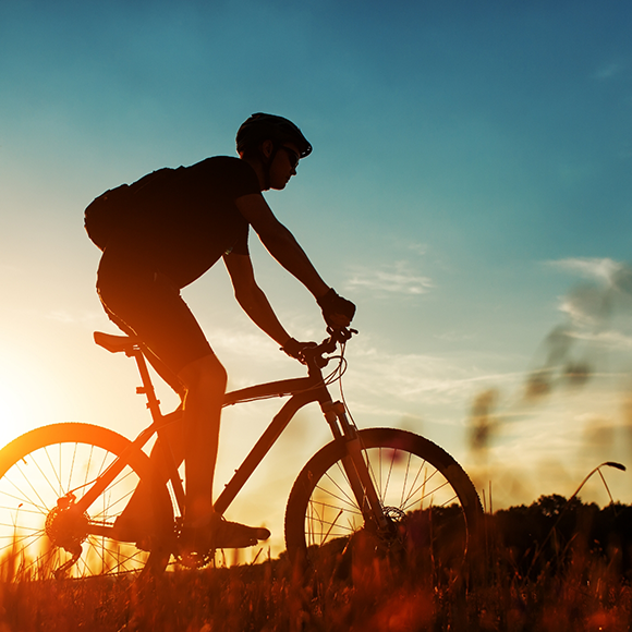 Person riding a bike at sunset