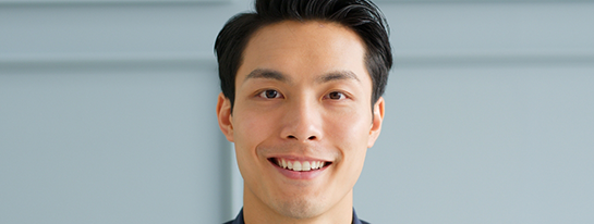 Young man with short dark hair smiling