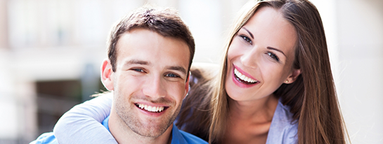 Young man and woman smiling and hugging