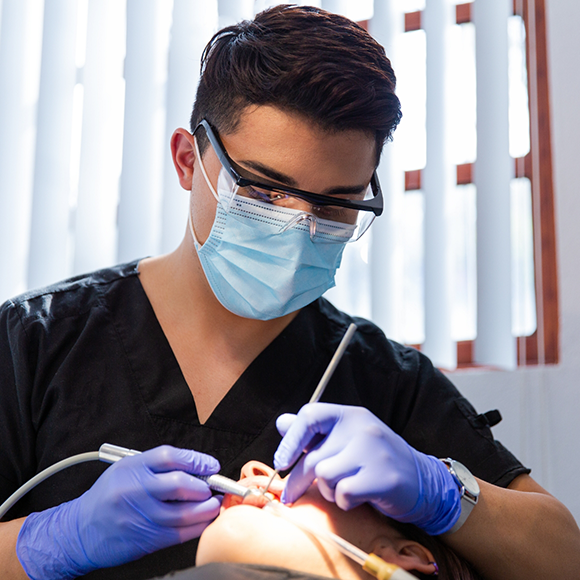 Dentist conducting an oral cancer screening on a patient