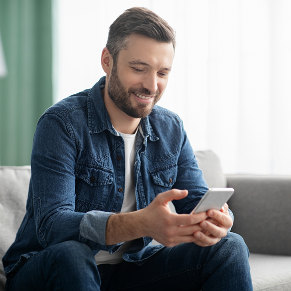 Man smiling while scrolling on his phone