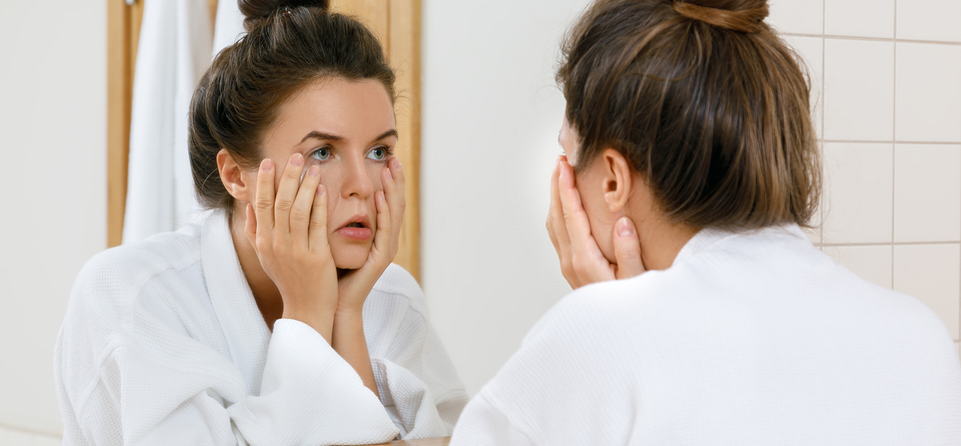 Woman looking at her reflection before root canal treatment in Altavista