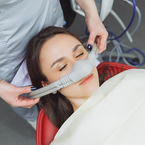 Woman in dental chair with a nitrous oxide mask over her nose