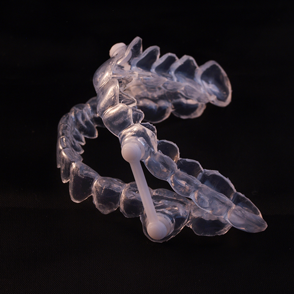 Clear oral appliance against a black background