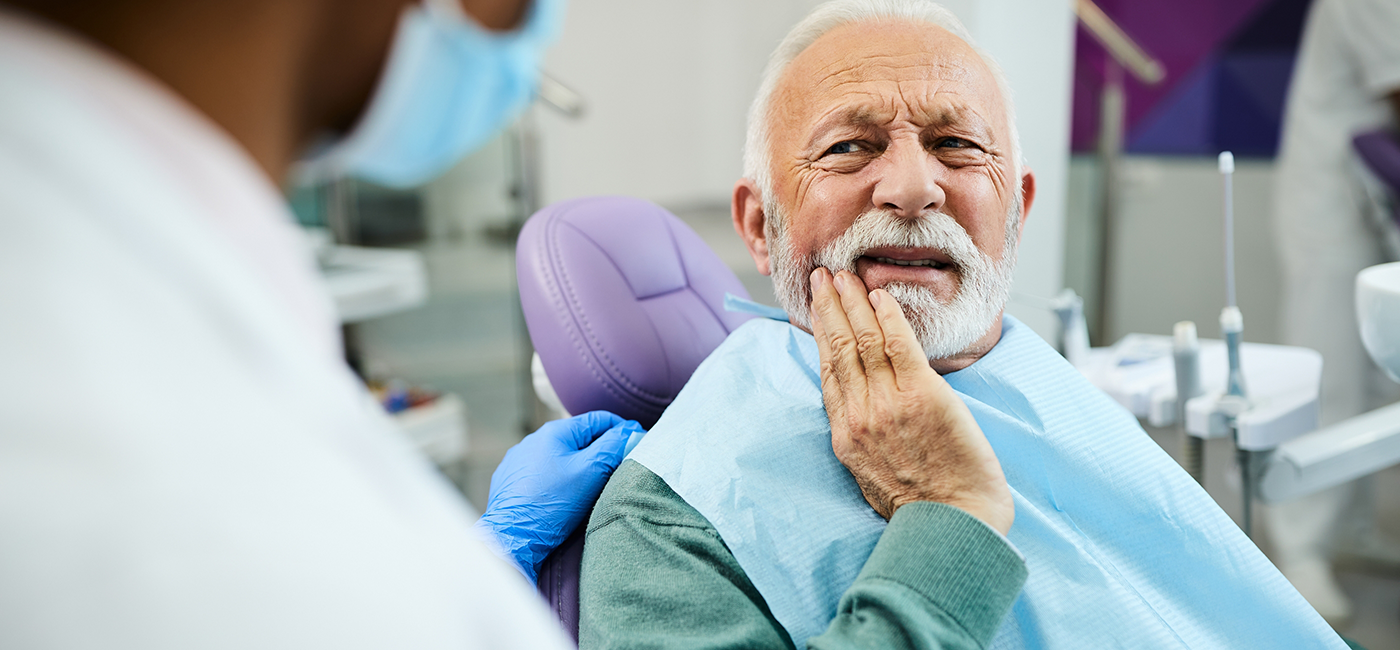 Man holding his jaw in pain talking to his dentist about T M J treatment in Altavista