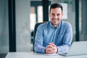 Man sitting at his desk smiling